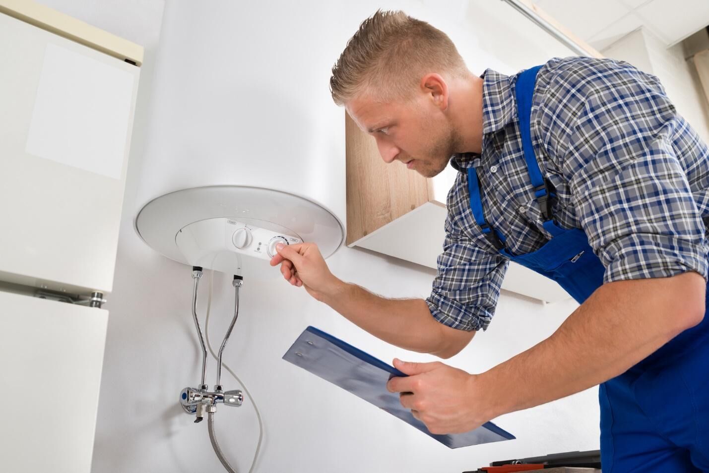 Plumber working on appliance in Perth home